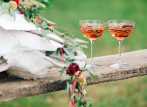 Two cocktails on outdoor table setting.