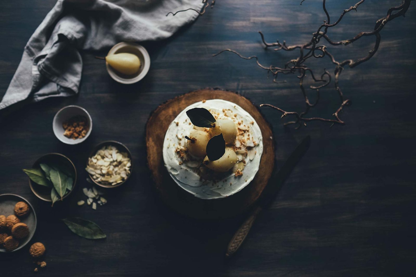 A rustic cake with cream and dark chocolate decorations on a wooden board.