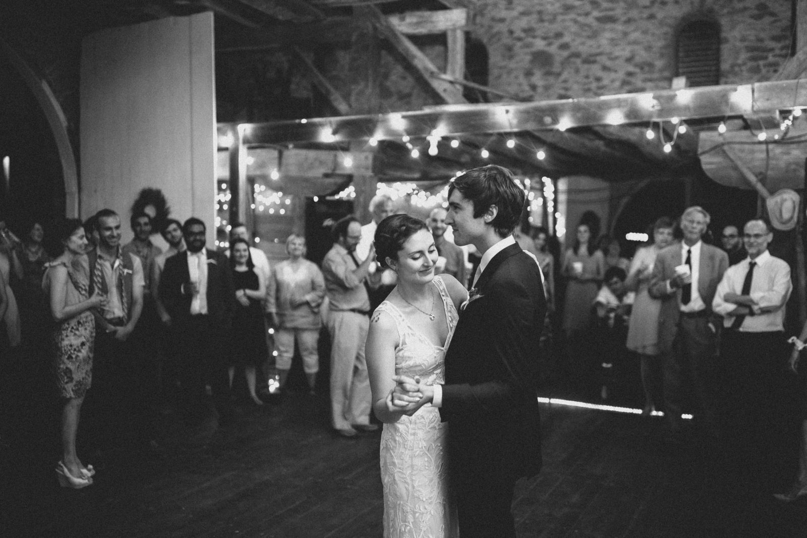 A couple shares a dance at a wedding reception filled with guests.