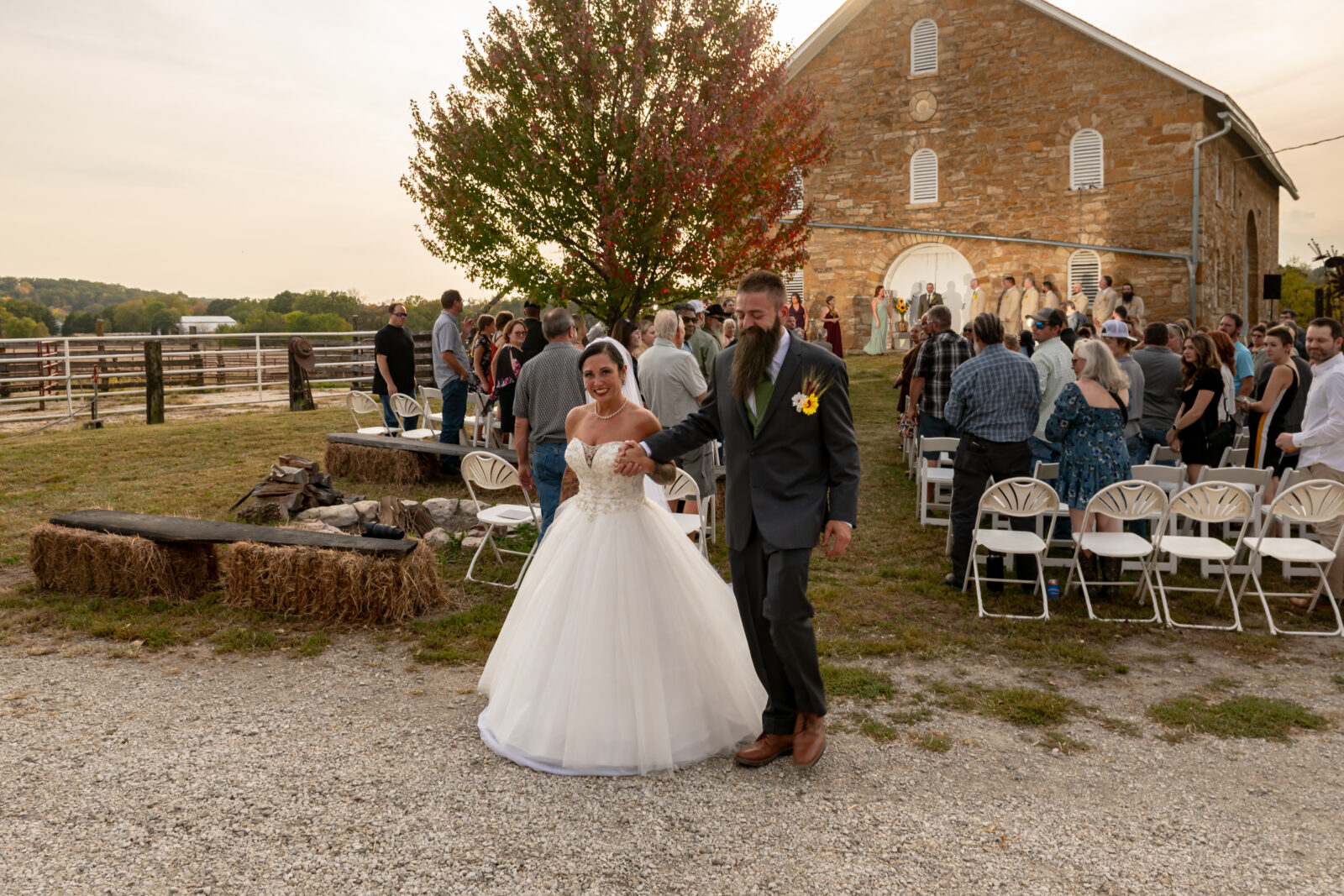 Bride and groom posing happily outdoors at their wedding reception.